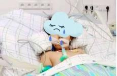 طفلة فلسطينية تجلس عدى سرير المرض وتتلقى العلاج اللازم لعيونها