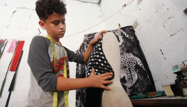الطفل أحمد عباس يحترف مهنة الخياطة (2).jpg