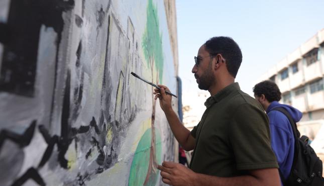 بالصور نشطاء من غزة يرسمون جدارية تندد بالإبادة البيئية وتوجه رسالة إلى قادة مؤتمر المناخ في البرازيل