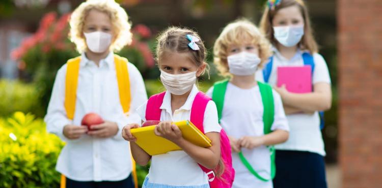 طلبة مدارسة يرتدون قناعا للحماية من كورونا.jpg