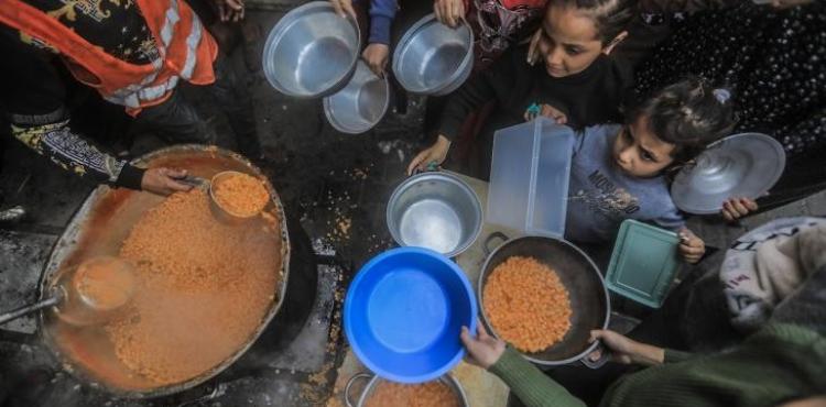 أطفال في غزة ينتظرون طهي الطعام لهم في ظل العدوان الإسرائيلي على القطاع.jpg