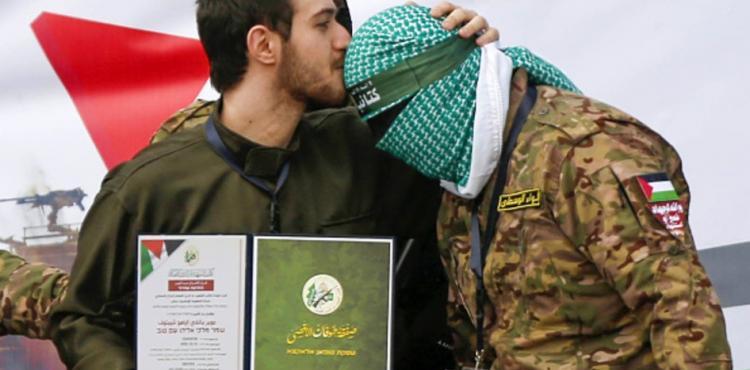 جندي اسرائيلي يقبل رؤوس كتائب القسام.jpg