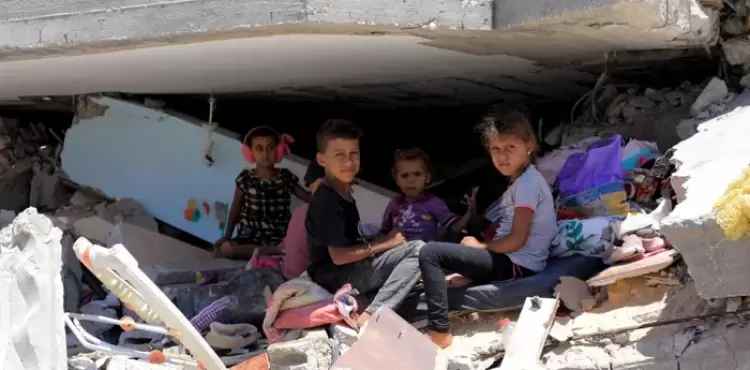 أطفال فلسطينيون يتواجدون بين المباني المدمرة في مدينة خان يونس جنوب قطاع غزة - أرشيفية