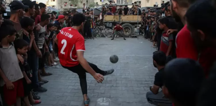 شباب ينطمون مباراة كرة قدم رغم الحرب.webp