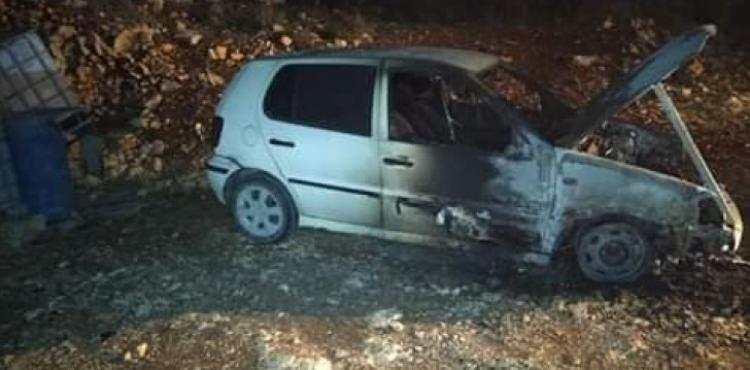 مستوطنون يحرقون مركبتين ويخطون شعارات عنصرية