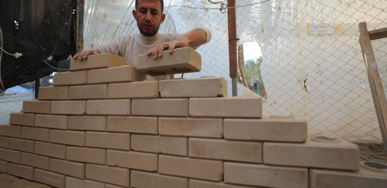 مواطنٌ غزي يُبدع في صناعة الطوب لتخفيف معاناة النازحين
