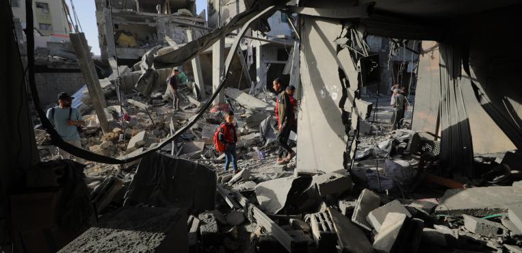 فلسطينيون يتفقدون منازلهم المدمرة عقب استهداف منزل في مخيم البريج وسط قطاع غزة