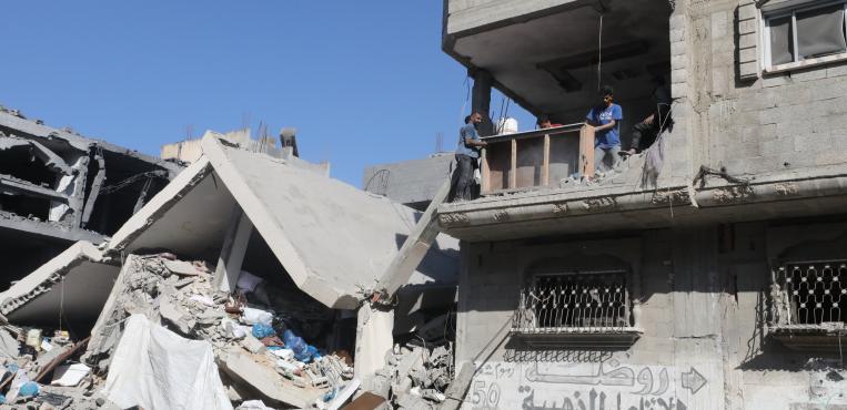 فلسطينيون يتفقدون منازلهم بعد غارة إسرائيلية علي مربع سكني في النصيرات