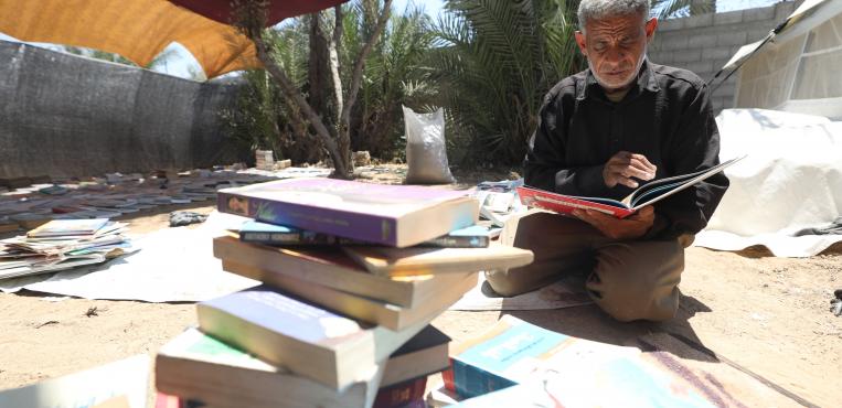 بائع الكتب الفلسطيني محمد رمضان سعد “56” عام يعيد بناء مكتبته داخل خيمة في دير البلح، مستخدماً كتباً أنقذها من أنقاض منزله في شمال غزة،