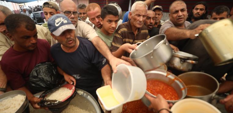 فلسطينيون يقفون أمام طوابير طويلة للحصول علي الغذاء