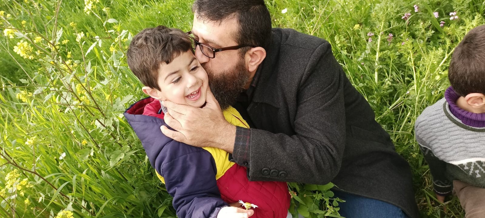 خضر عدنان يقبل أحد أبناءه.jpg